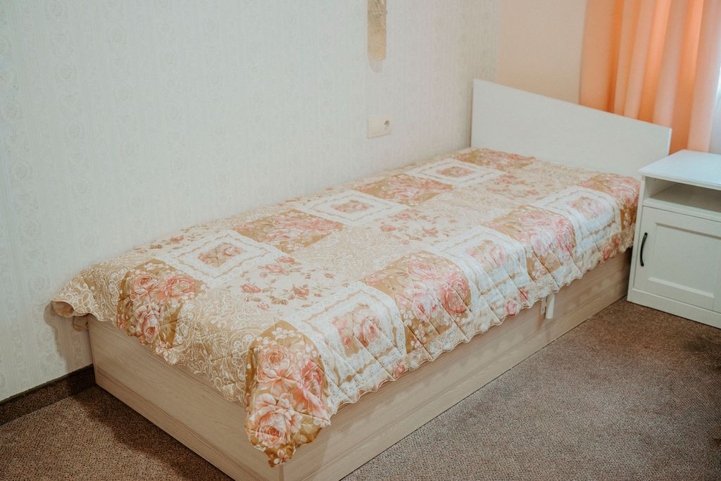 Стая в Мари Дар с оправено легло с флорална покривка и нощно шкафче